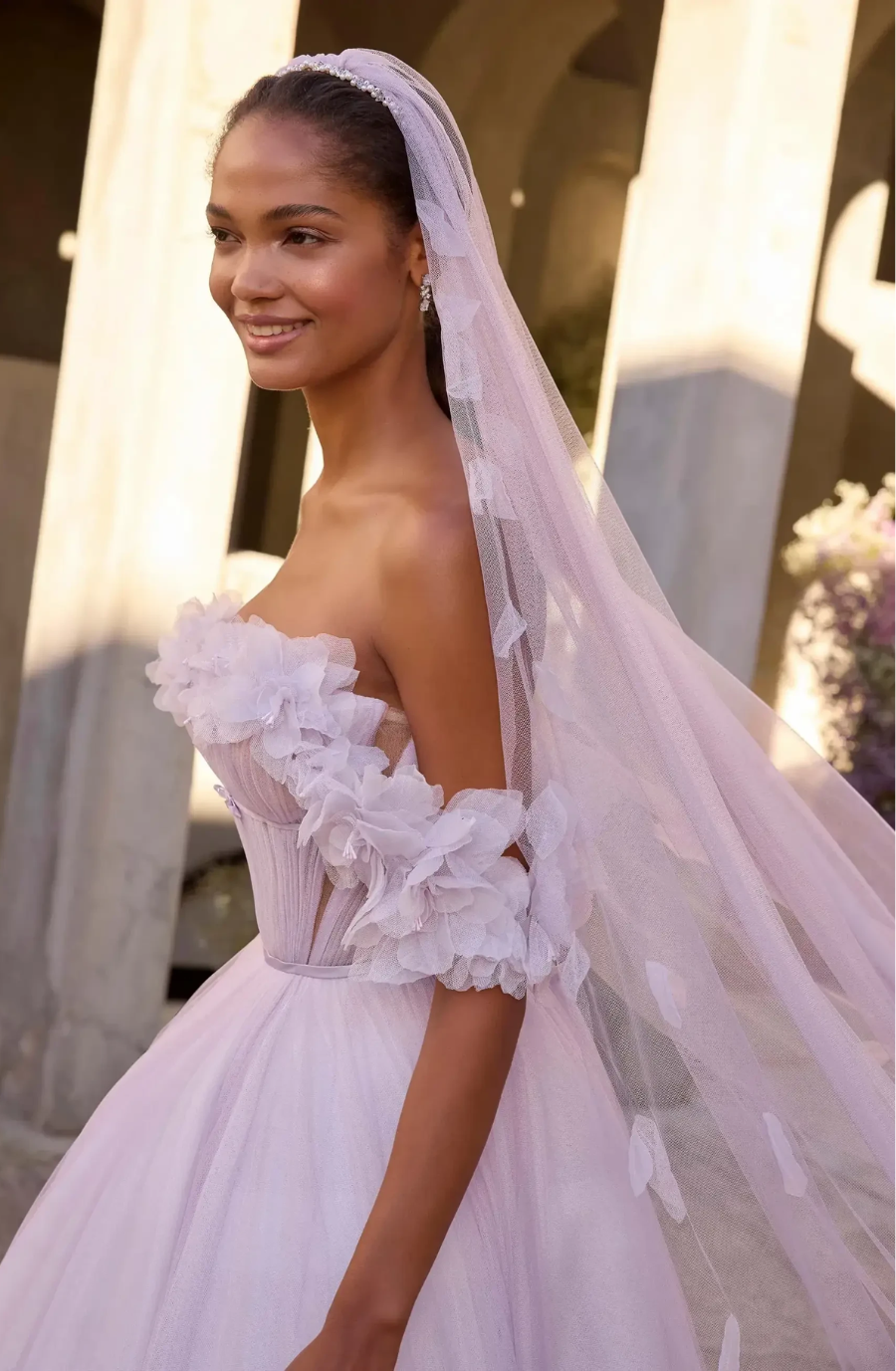 model is wearing an off the shoulder wedding dress