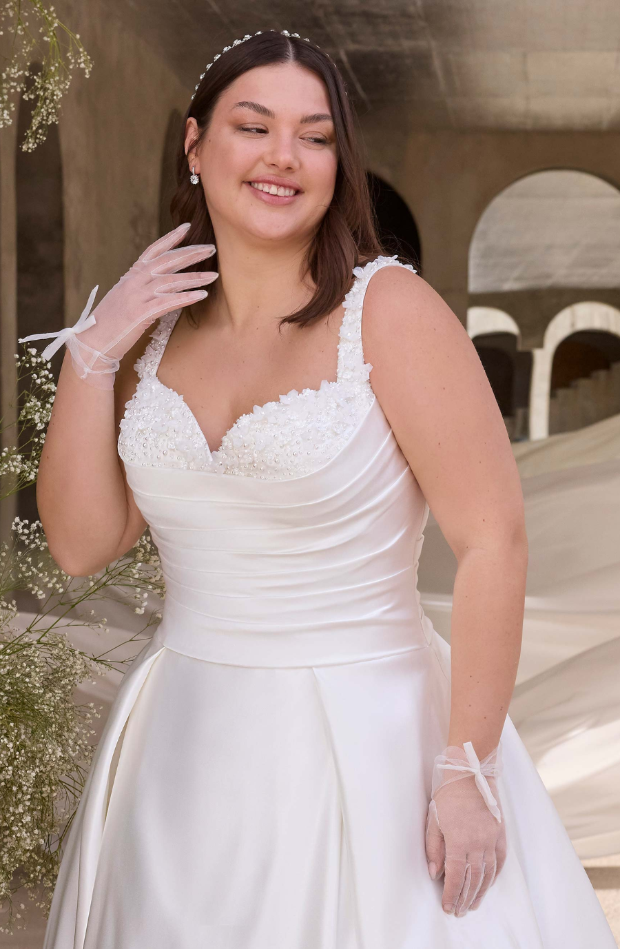 model is wearing a sleeveless plus size a-line bridal gown