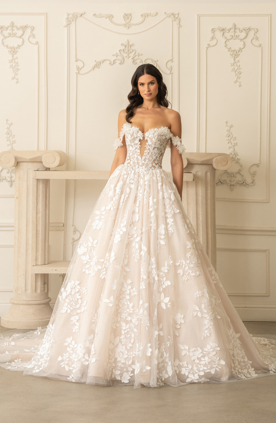 model is wearing an off the shoulder ball gown